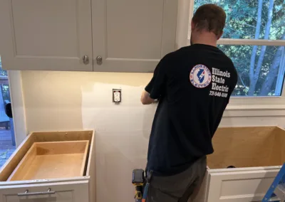 A man installing a cabinet in a kitchen.