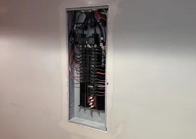 A room with an electrical panel in the wall.